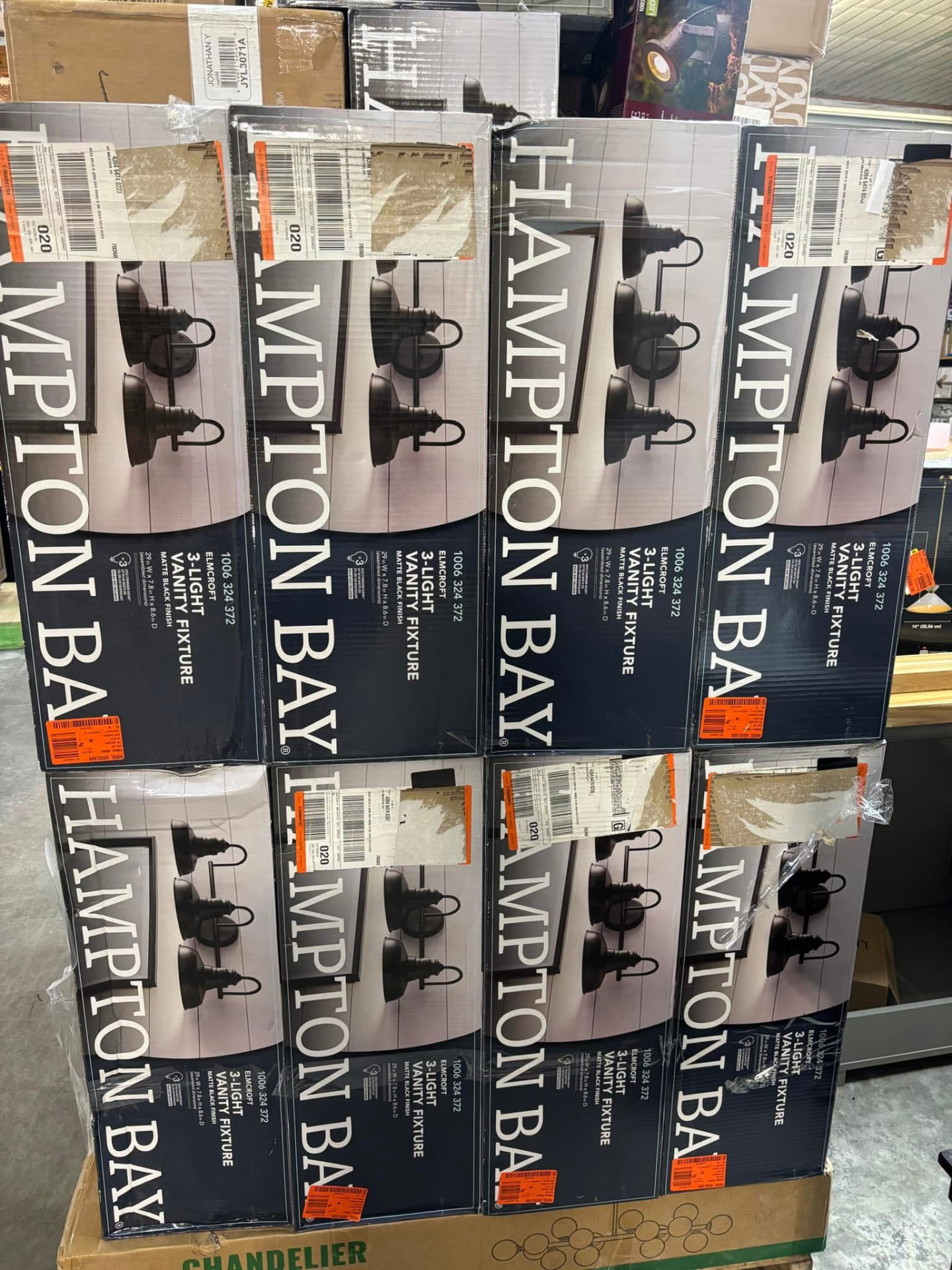 Pallet of boxed Hampton Bay Elmcroft three-light matte black vanity light fixtures